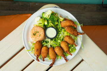 camarones empanizados con relleno ensalada y acompañado de arroz en restaurante de mariscos