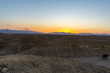 Sunset in the Hurghada desert, with the desert mountains on the horizon