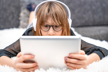 teenager with headphones and tablet on couch. children and modern technology, generation z