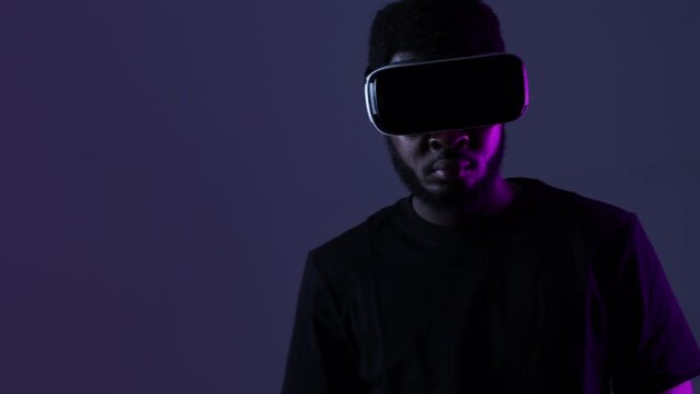African American guy in Smart glasses of virtual reality. Augmented reality game, future technology, AI concept. VR. Neon light.