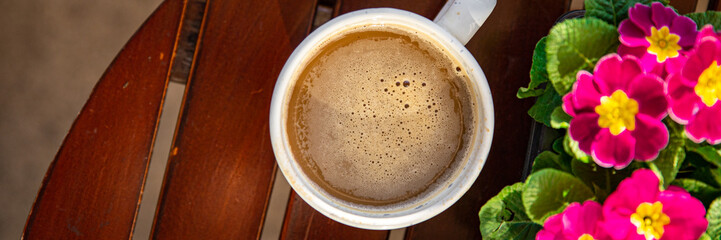 cup of coffee and spring flowers primrose multicolored on the table copy space food background rustic top view