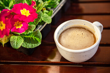 cup of coffee and spring flowers primrose multicolored on the table copy space food background rustic top view