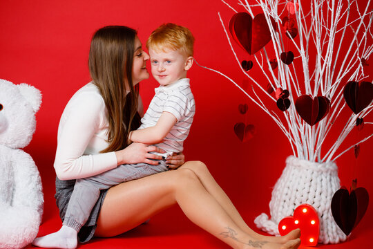 14.02.23. Vinnytsia, Ukraine: A brother and sister play at home. Red background. February 14 is Valentine's Day