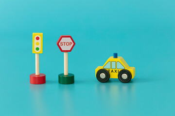 Wood sings: traffic light with yellow taxi on blue background isolated. Symbols: wood toys for kids.