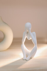 White gypsum decorative figure against beige background with copy space. Concept of template for website or commercial banner