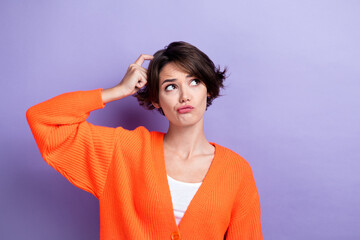 Photo of doubtful unsure lady dressed orange cardigan finger head looking empty space isolated purple color background - obrazy, fototapety, plakaty