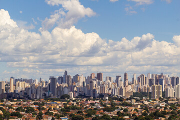 Cidade de Goiânia vista do Morro do Além, com muitos prédios e céu nublado ao fundo.