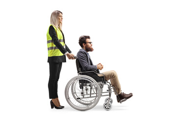 Female special assitance worker standing behind a man in a wheelchair