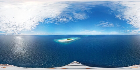 Panoramic view directly above the luxury yacht, which is located next to a desert island in the...