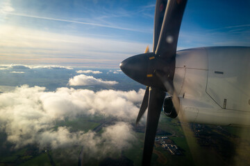 the propeller of a propeller plane flying above the clouds