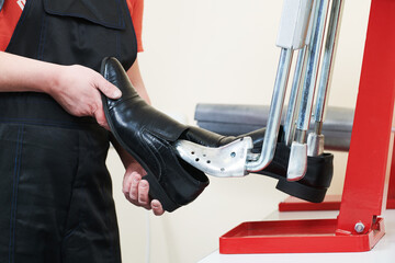 footwear stretching. male shoes in repair shop