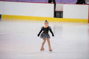 Obraz premium Figure skating of a little 4 year old girl. First competition. Excitement, pride.