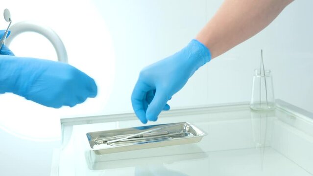 hands in hygienic gloves male female doctor nurse take tools from tray glass table dentistry curette gracie, piezo scaler, piezo scaler attachment, piezo scaler wrench, luxator dentistry cabinet tools