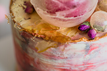 A detailed macro shot of an elegant cake adorned with floral and gold embellishments.