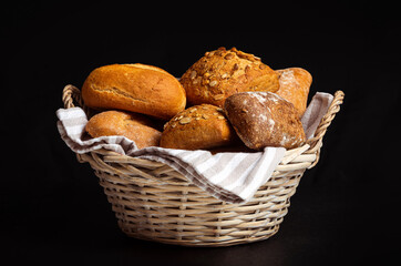 Basket with appetizing rolls on a black background
