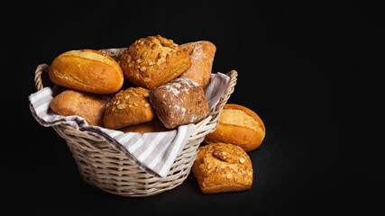 Basket with appetizing rolls on a black background