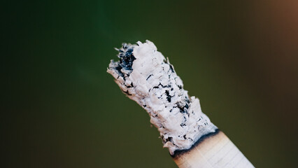 Closeup of a burning cigarette against blurred background
