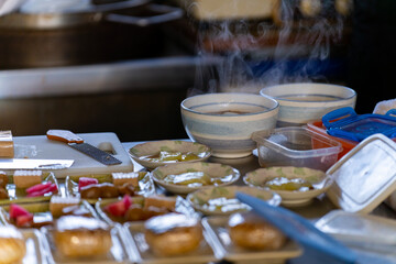 Chef preparing Japanese food breakfast set rice ball with soup and vegetable salad on serving tray on the table at local Japanese restaurant. Food and drink small business and holiday vacation concept