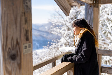 Asian woman relaxing at wooden seat and pavilion rest stop on the mountain during travel on road...
