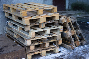Wooden shipping pallets stacked on top of one another outdoors.