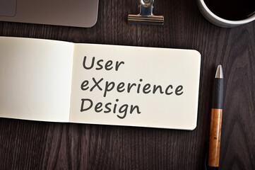 There is notebook with the word User eXperience Design. It is an eye-catching image.