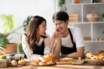 Young Asian couple spending their quality time together in the modern kitchen room, preparing their delicious food together.