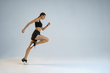 Fototapeta na wymiar Athletic active woman running on studio background. Dynamic movement