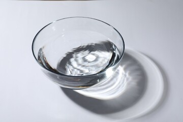 Glass bowl with water on white background