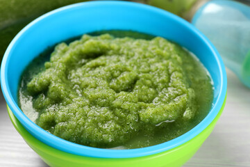 Healthy baby food. Bowl with tasty broccoli puree on white table, closeup