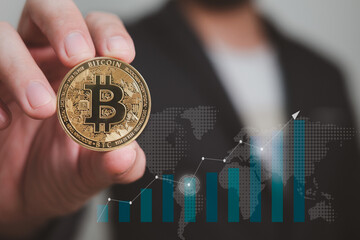 businessman holding bitcoin with graphic of growing in investment, concept of future investment in cryptocurrency or trading with digital currency on the internet
