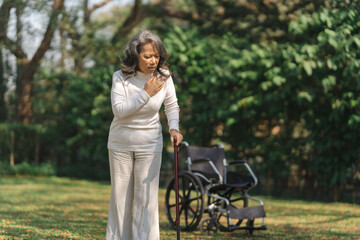 Elderly mature asian woman with bench at park outdoor, have a illnesses related to cardiovascular disease