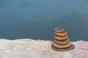 Zen stones placed near the river background.