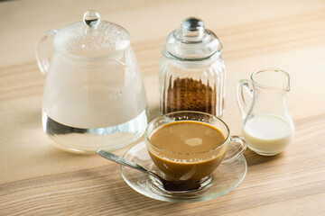 cup of hot Intense coffee dark shot in glass on wooden table with beans with crema. coffee beans and cup full of Intense dark shot coffee in glass cup