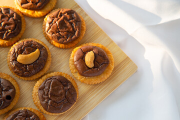 High angle view a group of cracker with brownies on a wooden chopping board