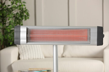 Modern electric infrared heater in cozy room