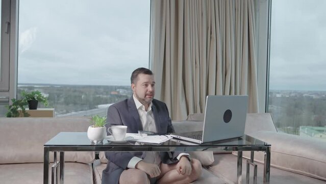 Man in suit without pants working online. home office, video conference, self-isolation concept. Businessman working at home. Remote work, work on the Internet, remotely