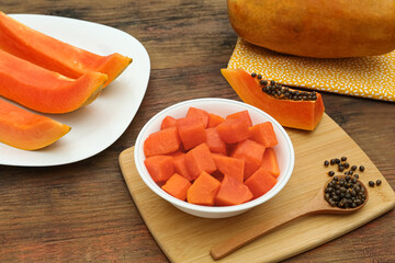 Tasty cut and whole papaya fruits on wooden table, above view