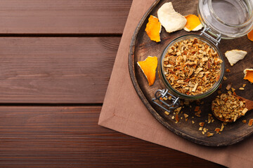 Tray with jar of dried orange zest seasoning on wooden table, flat lay. Space for text
