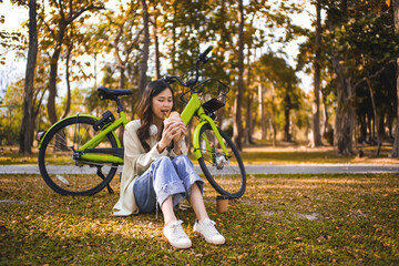 Young asian woman enjoy eating sandwich in garden.