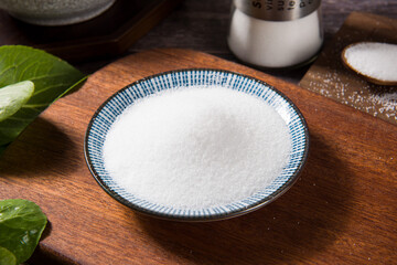 salt in a plate on wooden table