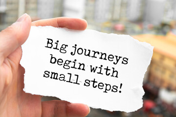 Big journeys begin with small steps. Words written under torn paper. Motivation concept text.