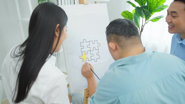 Asian happy family draw picture with young son in living room at home.