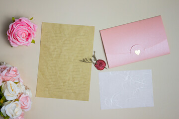 Letter concept with brown paper, pink envelope over the brown paper.