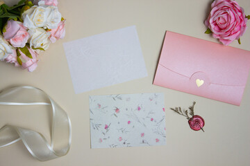 Letter vintage concept with roses, ribbon and pink envelope over the brown background.