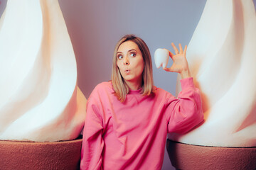 Confused Woman Holding a Tooth Next to Big Ice Cream Desserts. Patient experiencing problems after...
