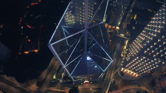 Aerial top down shot of flashing neon lights on Bank of China building In Hong Kong City at night