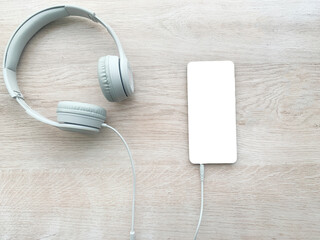 Fototapeta na wymiar headphones and phone on a wooden board