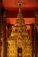 Golden Buddhist statues and carving showing intricate details and textures created by Buddhist...