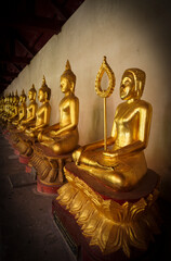 Golden Buddhist statues and carving showing intricate details and textures created by Buddhist...