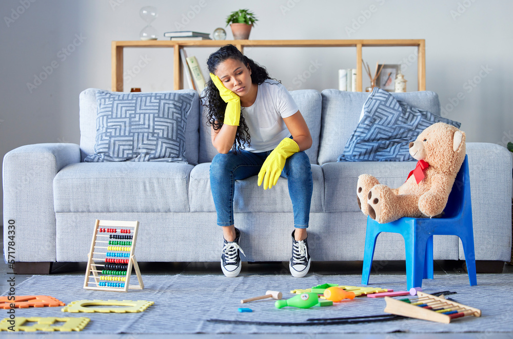 Wall mural Tired, cleaning and black woman in living room with chaos and stress from toys at home. Cleaner, stress and burnout from housekeeping work on a lounge couch ready for sleeping from anxiety and mess